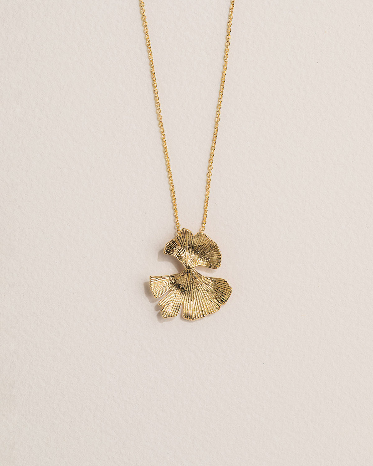 A 18k gold-plated necklace featuring a delicate floral design with petals fan-like in structure.