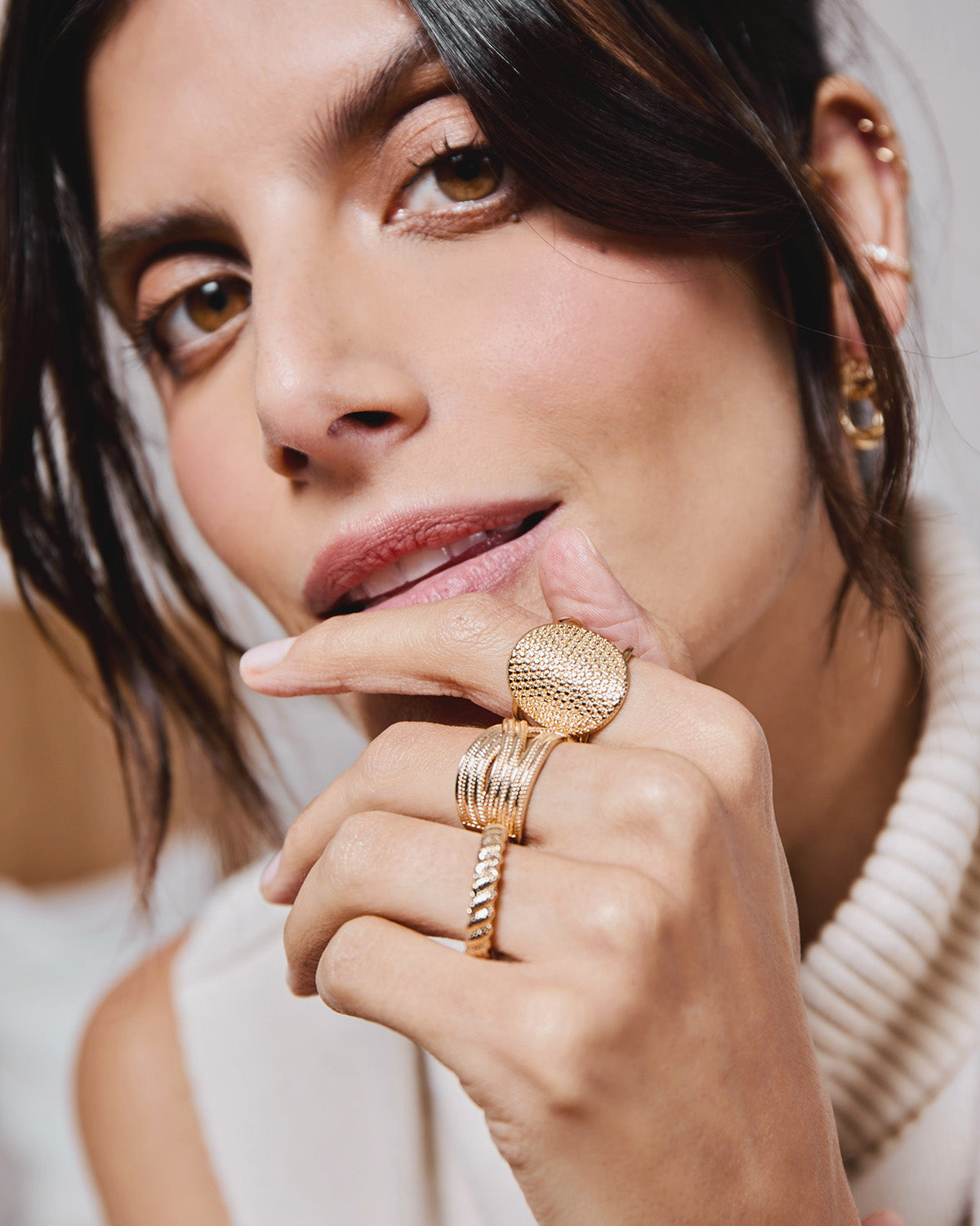Three 18k gold-plated rings worn by a model