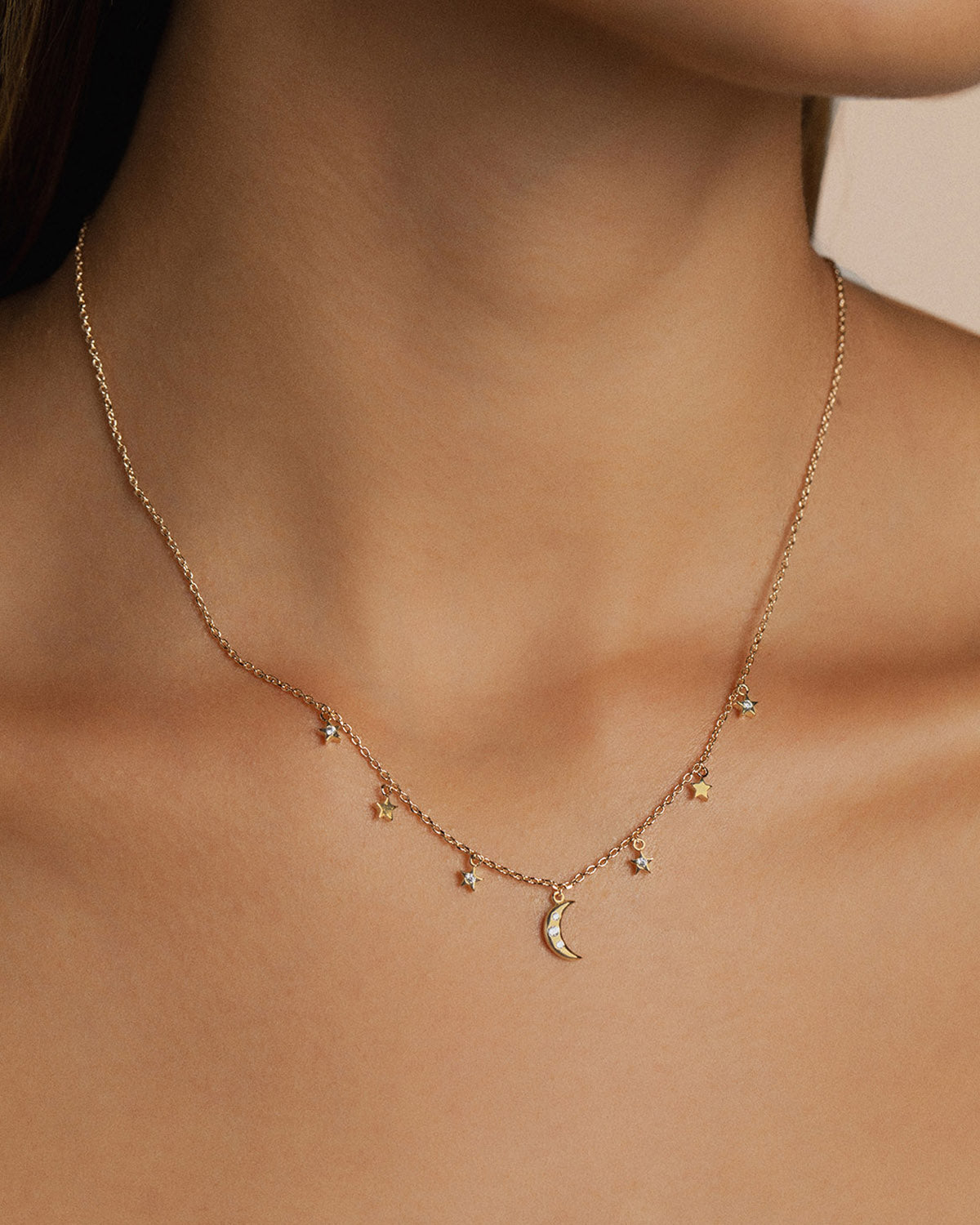A 18k gold-plated necklace adorned with stars and a large moon