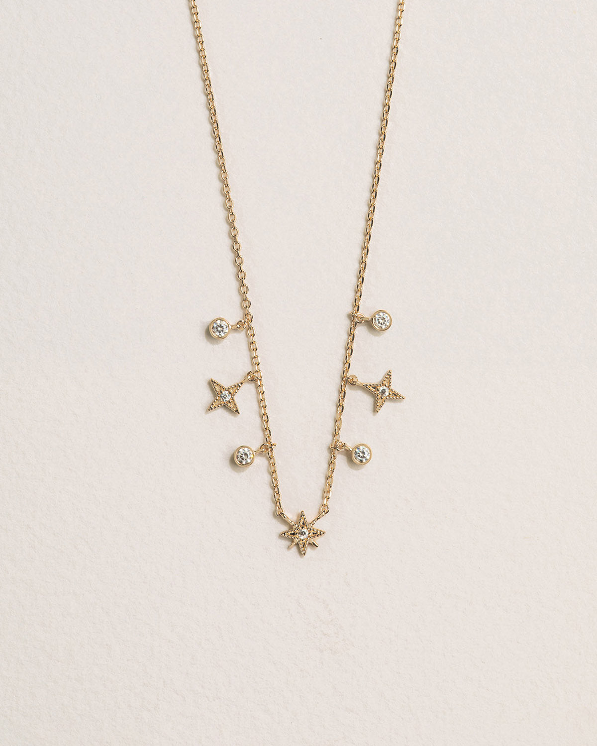A 18k gold-plated necklace with star-shaped charms and zirconia beads.