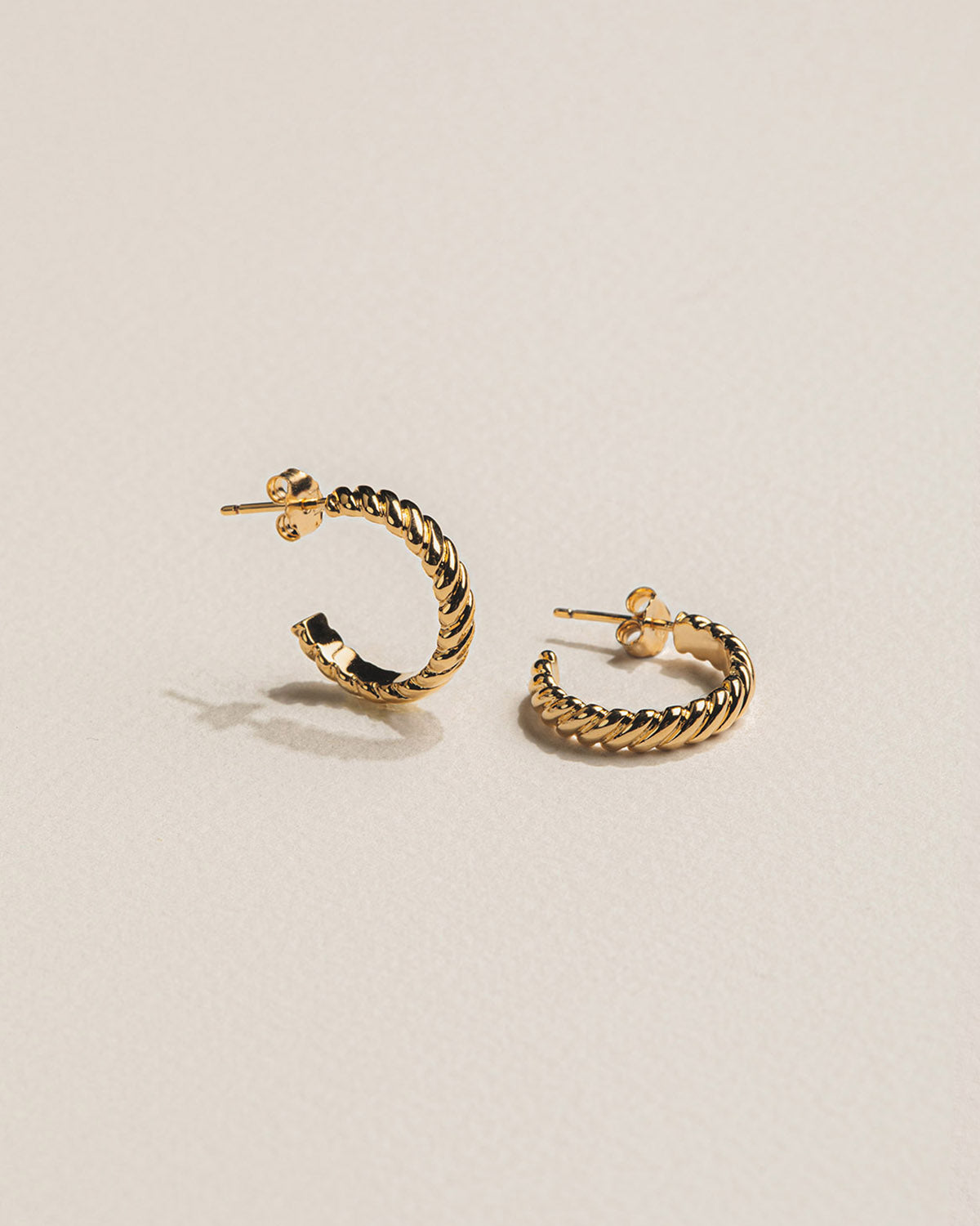 A 18k gold-plated pair of hoop earrings with a braided effect.