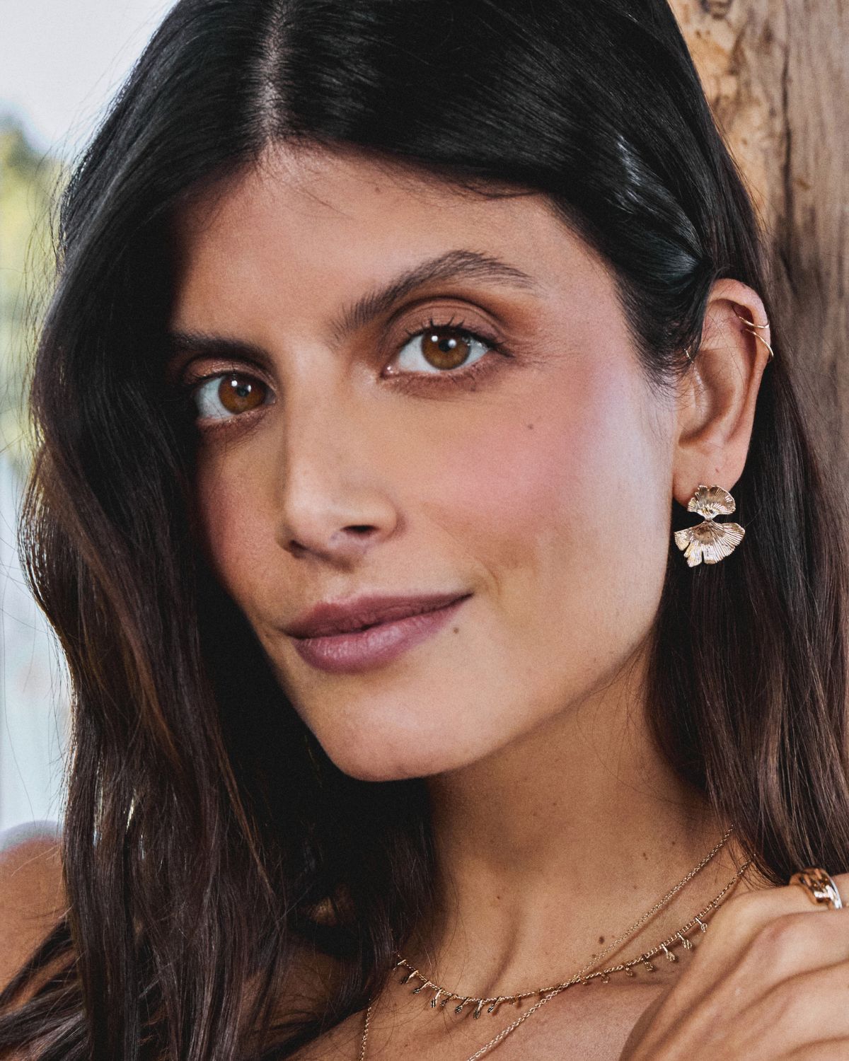 A 18k gold-plated earrings representing a floewer petal worn by a model 