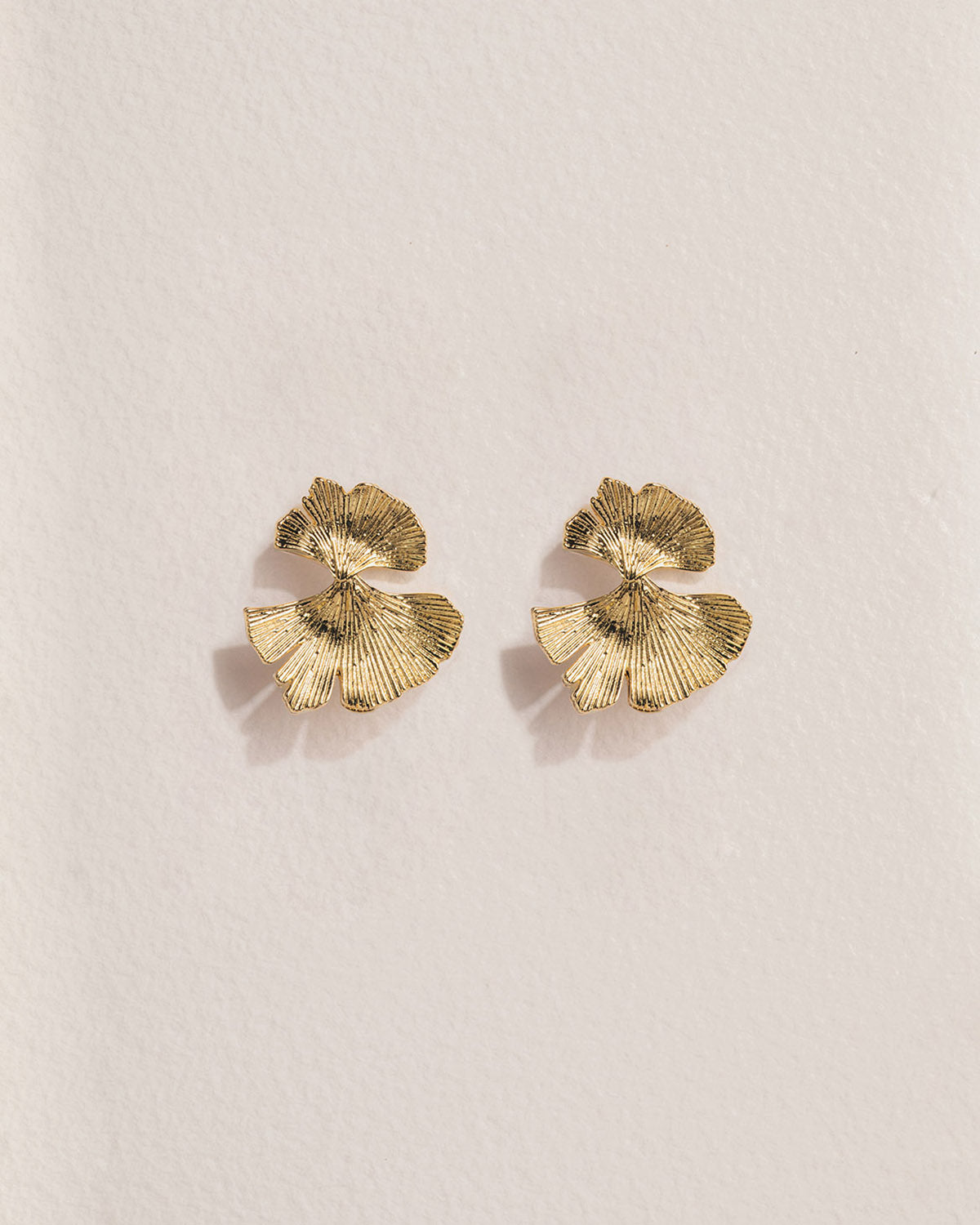A pair of 18k gold-plated earrings with a petal design.