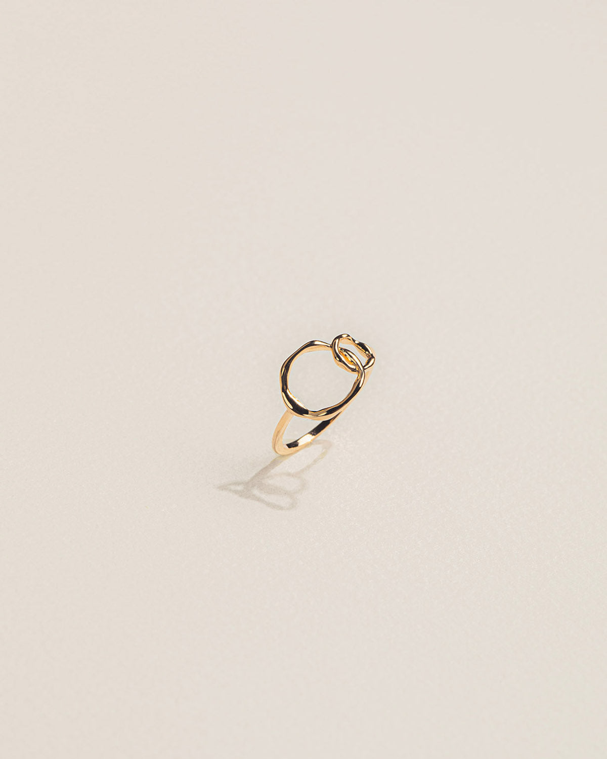 A 18k gold-plated infinity ring with two intertwined bands forming a knot.