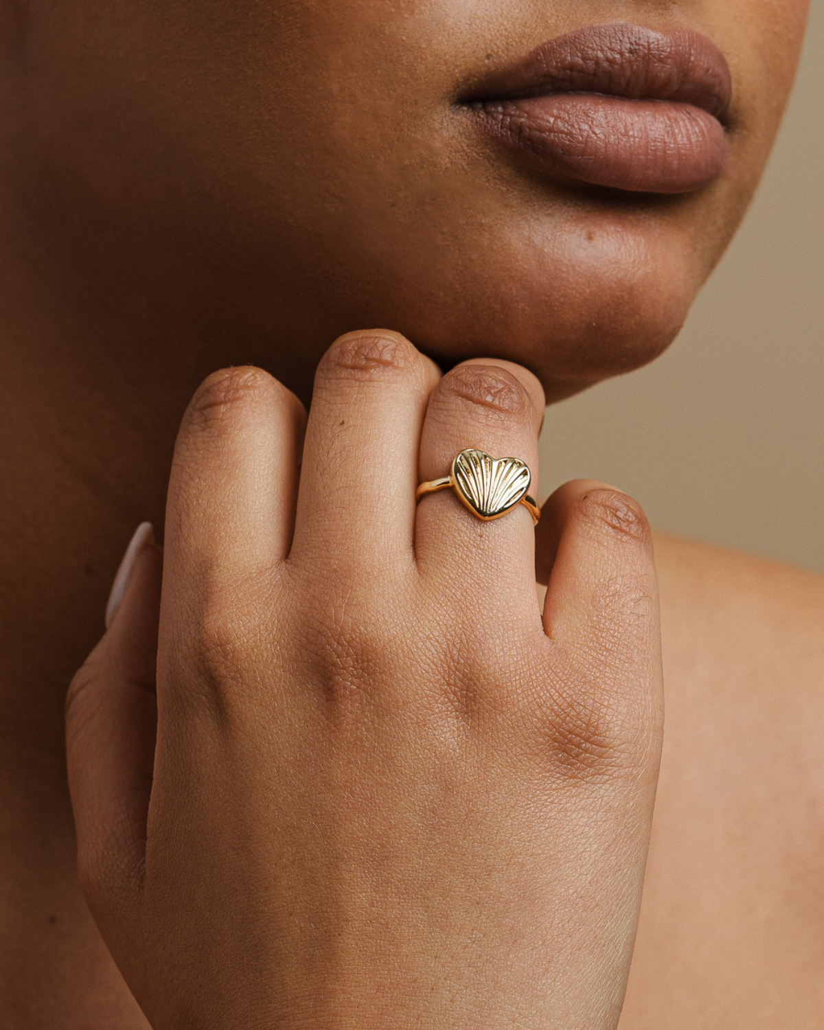 Close-up of a hand wearing a 18K Gold-plated ring with a shell design