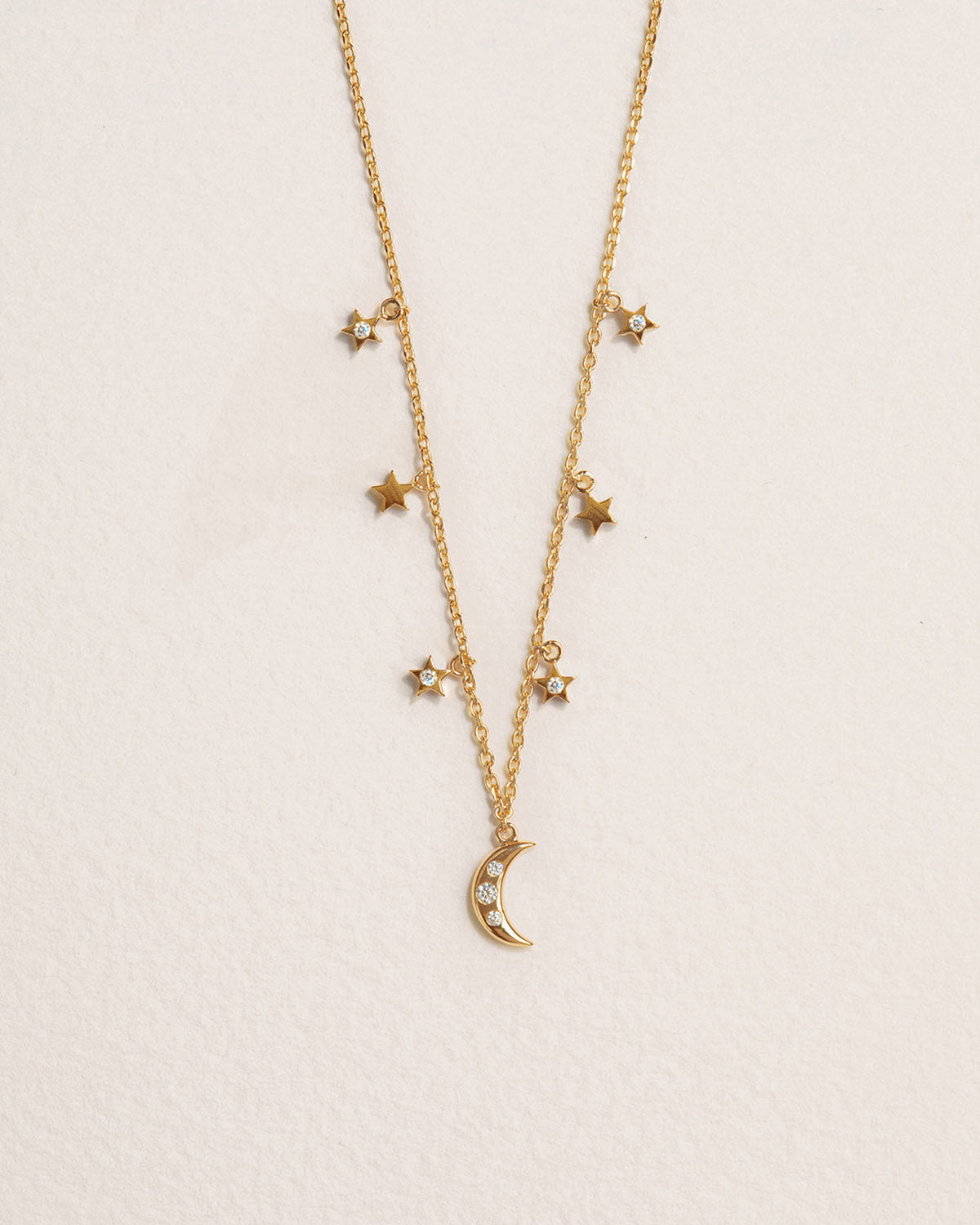 A 18k gold-plated necklace adorned with stars and a moon
