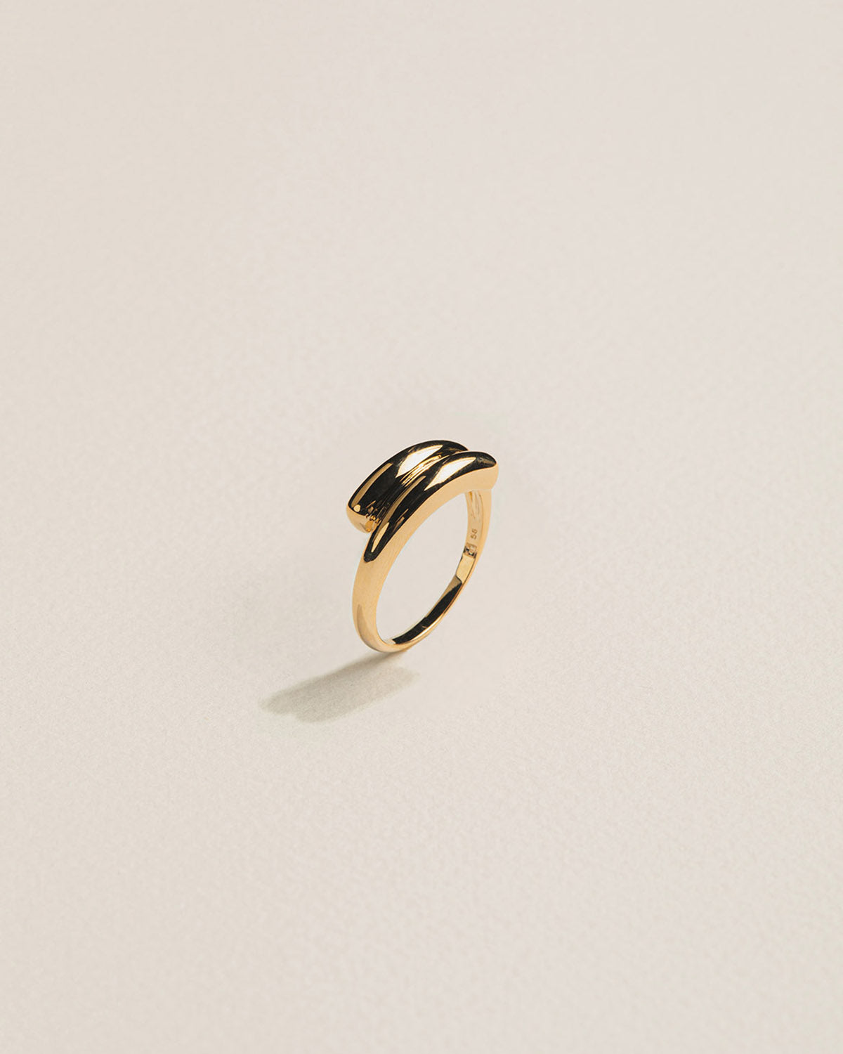 A 18k gold-plated contemporary and organic ring with a volumetric effect, featuring two arcs that overlap.