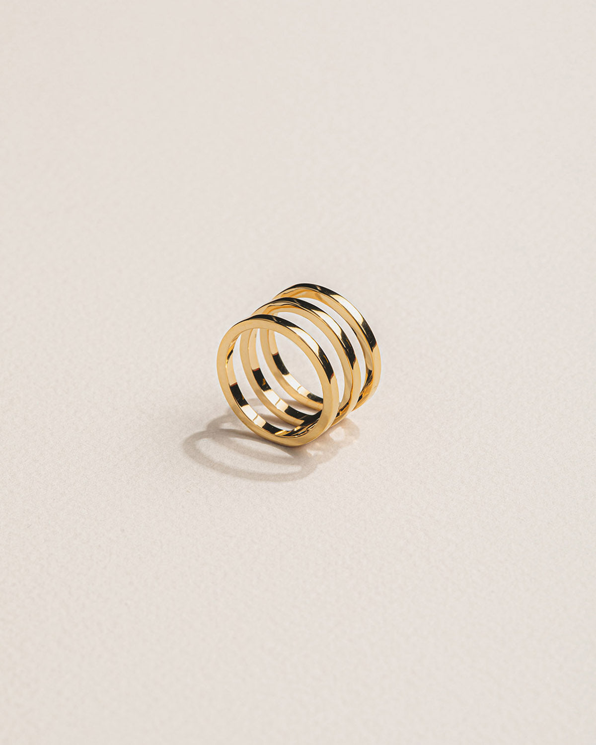 A 18k gold-plated geometric design ring with three parallel bands.