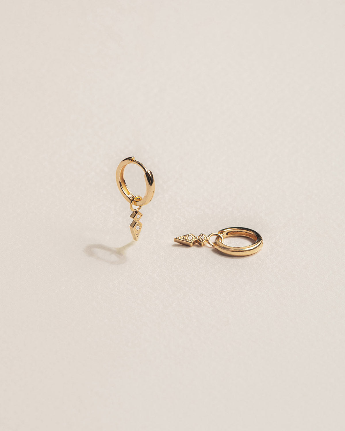 A pair of 18k gold-plated ear cuffs with a zirconium -set arrow design 