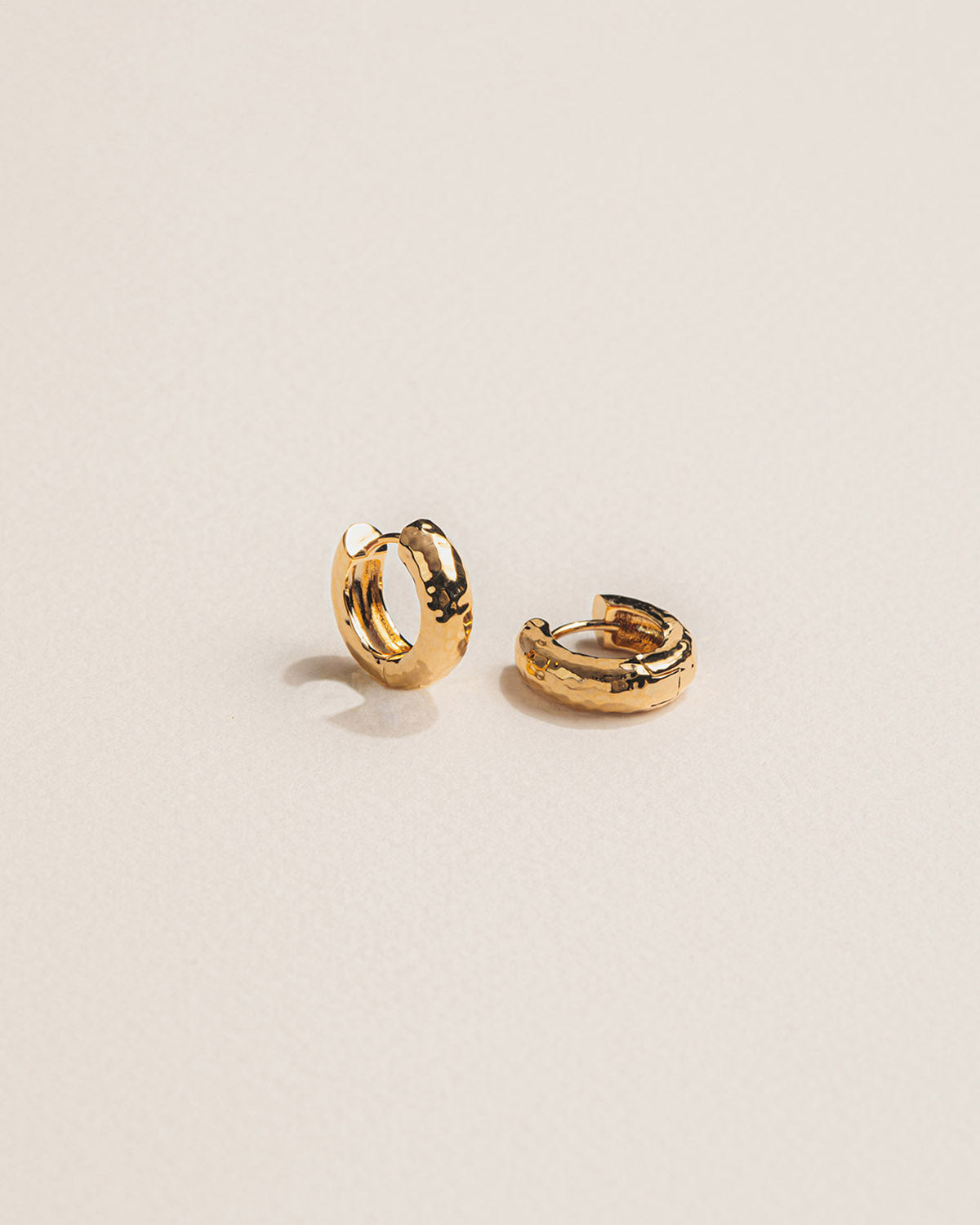 A 18k gold-plated pair of mini hoop earrings with a subtle, contemporary hammered effect .
