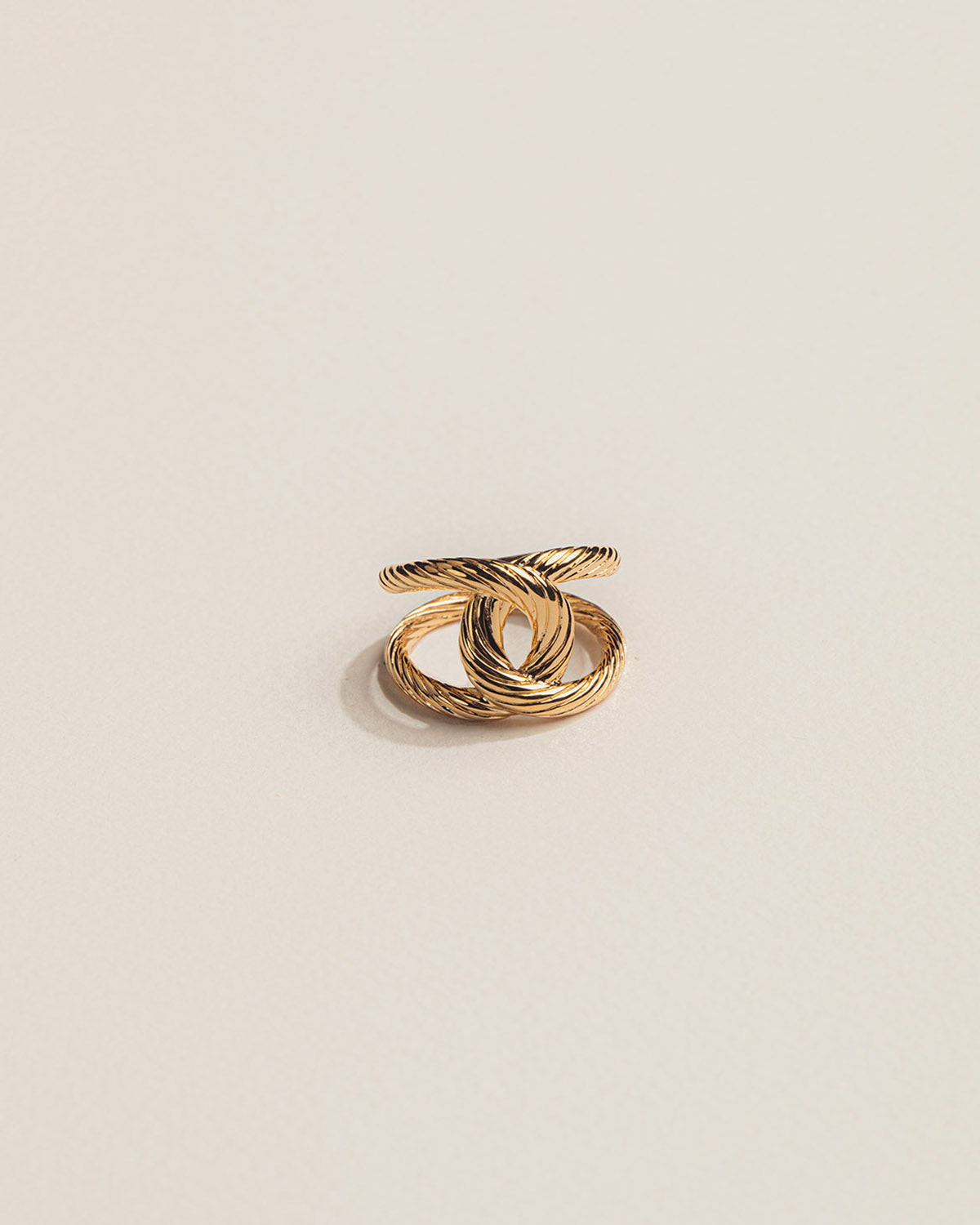 A 18k gold-plated braided ring where two cords intertwine.