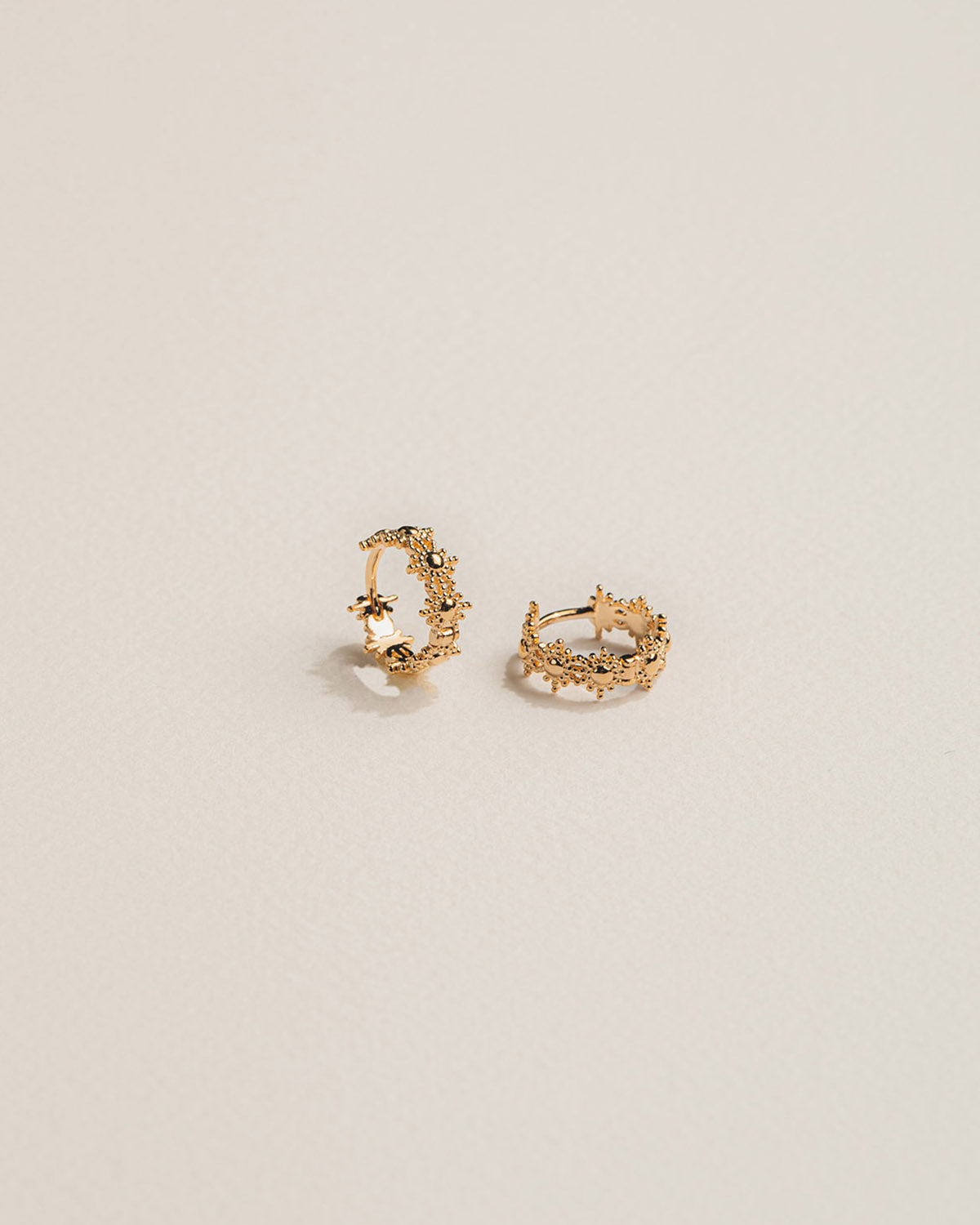 18k gold-plated Mini hoop earrings with gold crowns and star patterns.