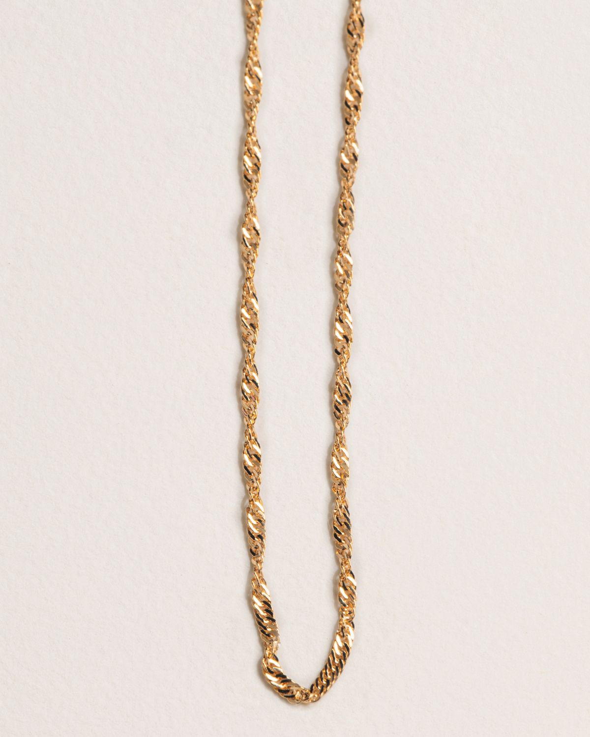 A 18k gold-plated necklace with a twisted, interwoven chain design.