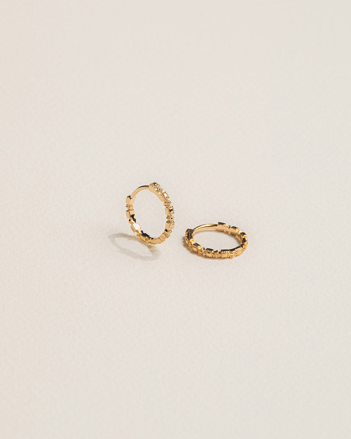 A pair of 18k gold-plated hoop earrings with a pearly pattern
